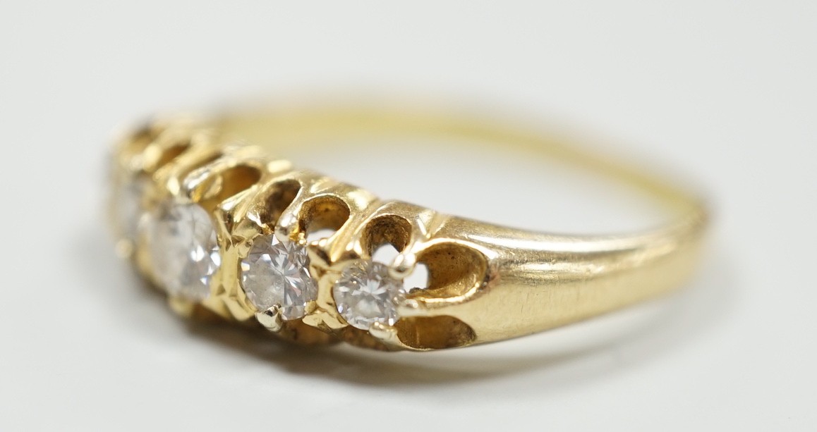 An early 20th century gold and graduated five stone diamond set half hoop ring, size O/P, gross weight 4.3 grams.